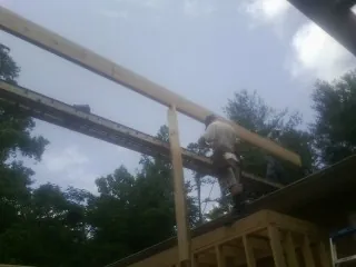 Carpenter setting a ridge beam over a new addition frame — Ice Dam Removal by Roofing Brothers in Olney