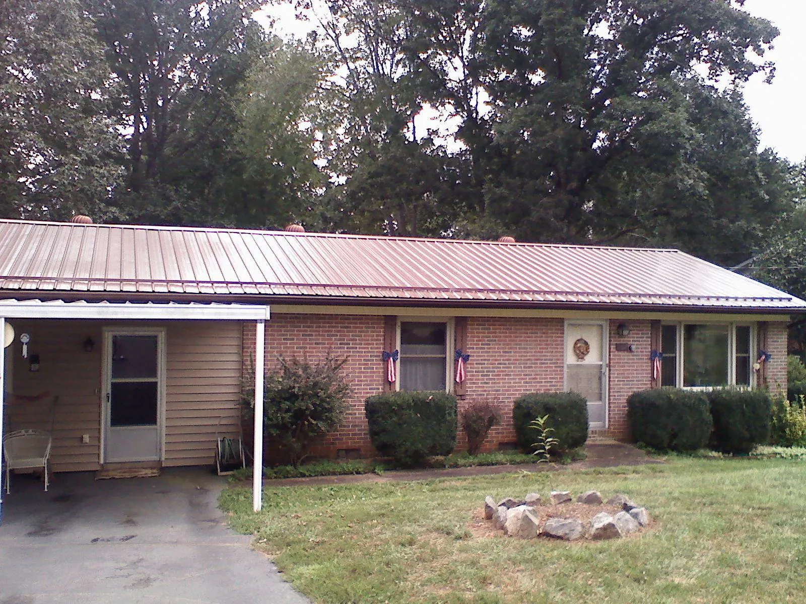 Bronze metal roof and carport on a brick ranch home — Roof Repair work by our crew in Olney